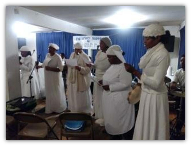 The Sisters In Christ is praising the Lord at the Communion and Feet Washing Service. They are singing the song, “Hold to God’s Unchanging Hand”.